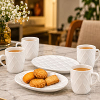 Anupam white ceramic mugs and serving plates arranged for tea and biscuits