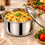 Anupam stainless steel serving pot with glass lid shown with rice in kitchen setting